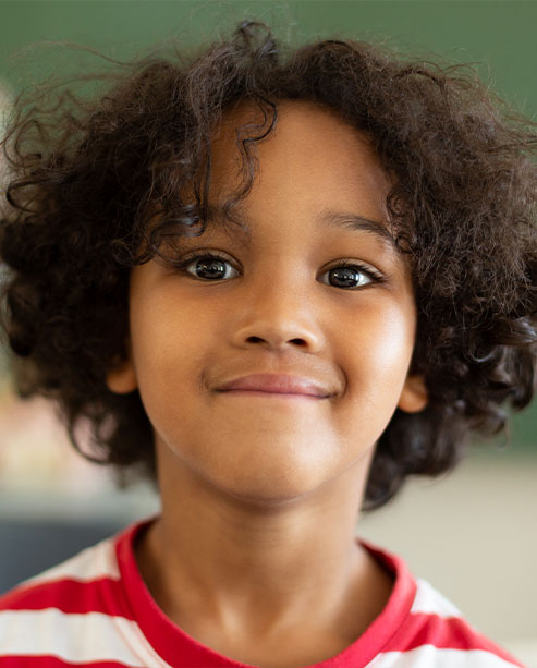 Criança sorrindo em ambiente acolhedor de clínica infantil
