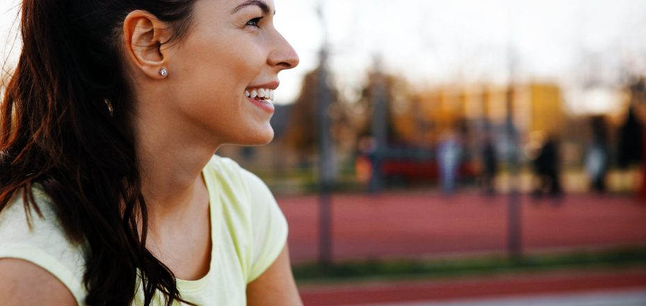 Beautiful sporty female jogger tired after running